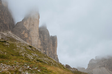 Moody picture of Dolomite peaks. Autumn in Dolomites. Huge peaks in clouds in Italy. 