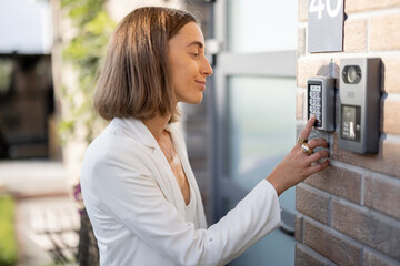 Woman entering code on a keyboard to access a door
