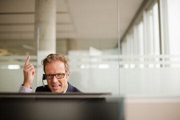 Businessman talking on headset in office