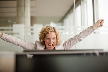 Businesswoman cheering in office