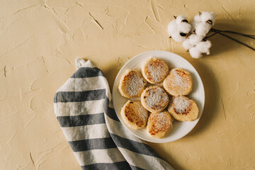Cottage cheese pancakes or syrniki with  on ceramic plate. Delicious breakfast or brunch. Top view. Copy space.