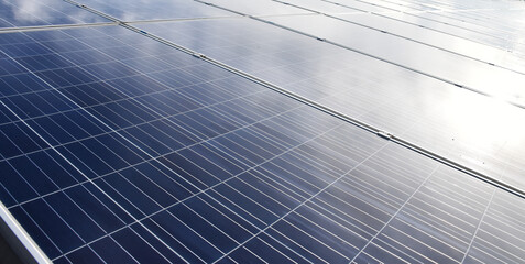 Photovoltaic roof with reflection of the Sunlight and clouds on the surface.