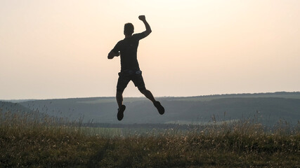 The sportsman jumps on mountain top