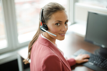 Businesswoman wearing headset at desk