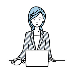 デスクで座ってPCを使っているスーツの女性