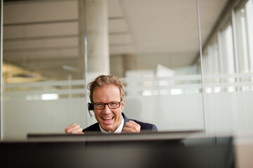 Naklejka na ściany i meble Businessman talking on headset in office