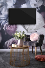 Modern wide screen TV on wall in room with stylish furniture