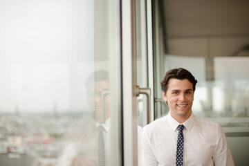 Fototapeta premium Businessman standing at office window