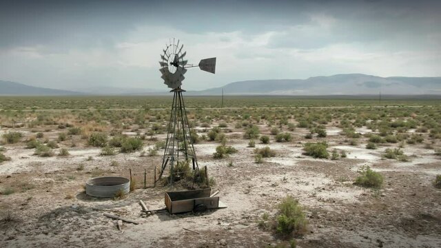 Aerial: weathervane and water trough on abandoned ranch in the Dessert, Denio, Nevada, USA