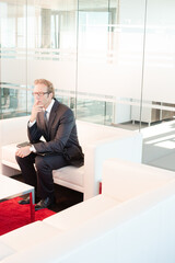 Businessman standing in office hallway