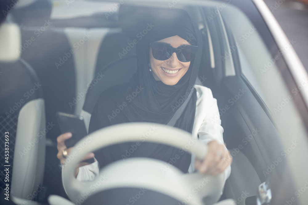 Wall mural muslim woman drives a car