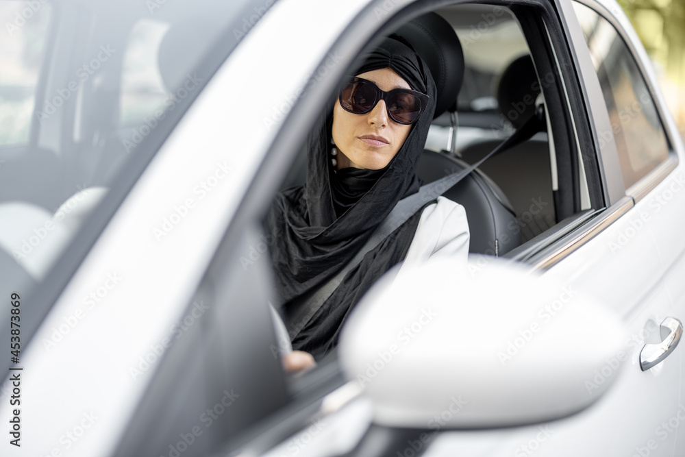 Wall mural Muslim woman drives a car