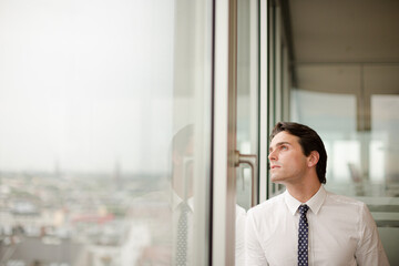 Businessman standing at office window