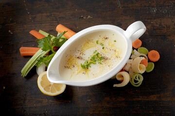 Lemon butter sauce with chopped parsley in gravy boat