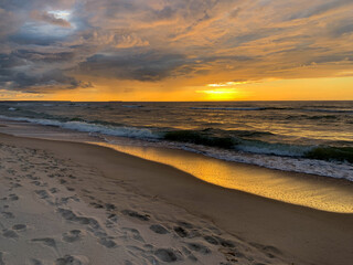 Peaceful sunset at the sea, sand beach, yellow orange sunset