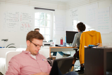Obraz premium Businessman using laptop in bean bag chair in office