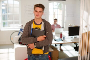 Businessman carrying folders in office