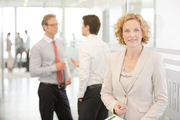 Businesswoman standing in office hallway