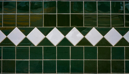 Vintage green tile wall with white diamond tile accents.    