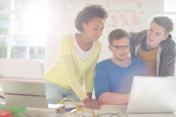 Business people using laptop in office