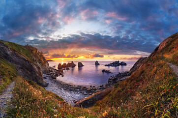 sunset on a rocky beach. Panoramic image of a beach