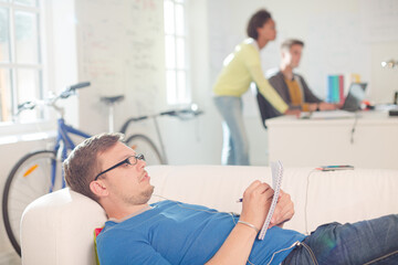 Obraz premium Businessman taking notes on sofa in office