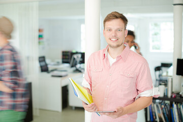 Obraz premium Businessman carrying folders in office