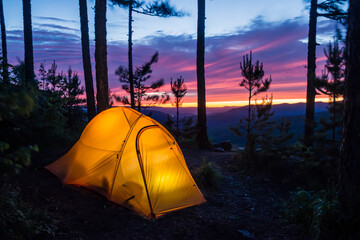 Luminous tent in the evening in the mountains