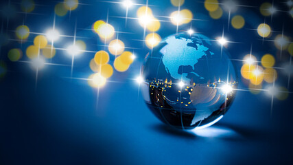 Glass earth globe sustainable sphere - merry christmas - earth ball and happy new year 2025 patriotic north and south america, usa, canada with golden lights and chain lights above a blue background. 