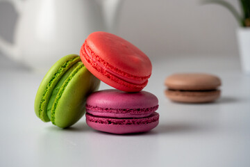 three macaroons on a white background. The back has a light blurred background. Side view. Delicious sweet dessert
