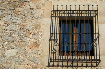 Fototapeta na wymiar Window with bars set in an old fortress stone wall