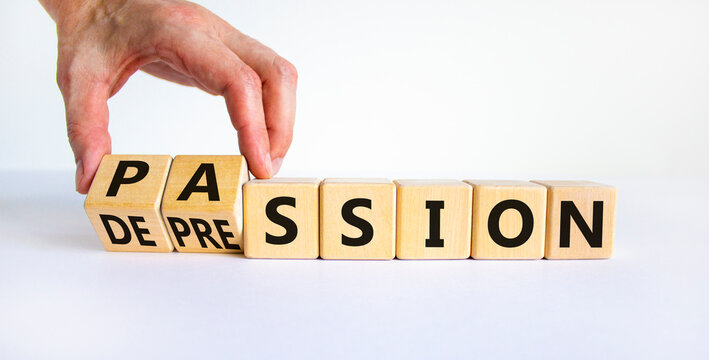 Passion or depression symbol. Businessman turns wooden cubes and changes the word depression to passion. Beautiful white table, white background, copy space. Business, passion or depression concept.
