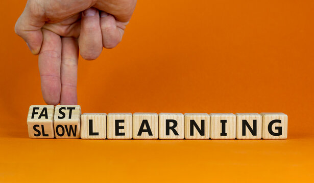 Fast or slow learning symbol. Businessman turns cubes, changes words 'slow learning' to 'fast learning'. Beautiful orange background. Business, education and fast or slow learning concept. Copy space.