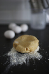 Portion of dough and flour on the kitchen table