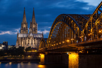 Fototapeta premium Historical buildings illuminated against blue hour sky late in summer in Cologne
