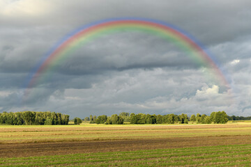 Beautiful countryside landscape with rainbow on the sky