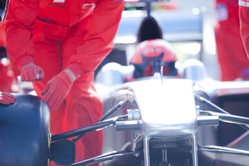 Racing team changing car wheel on pit stop