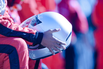 Close up racer holding helmet
