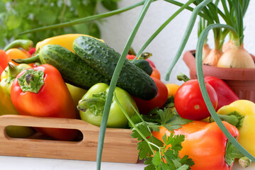 Sweet red pepper in a wooden tray on a white table
