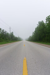 Fototapeta na wymiar Empty foggy straight road