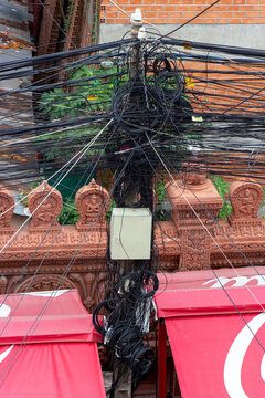 A wires attached to the electric mast. The chaos of cables and wires on an electric pole, Phnom Penh, Cambodia.