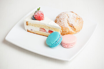 plate of desserts with cake, cookie, and macaroons 