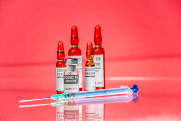 Viales medicamento con jeringa, vacuna Covid-19, fondo rojo