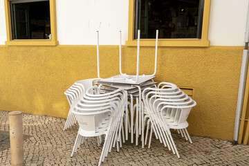 stack of tables and chair in an alley in Lagos, Algarve, Portugal