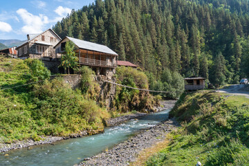 Fototapeta na wymiar Hanging bridge on a mountain river in the village. Tusheti. Georiga