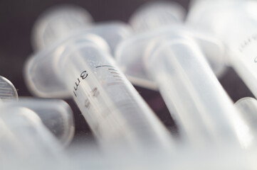Closeup shot of a bunch of new unused 3ml syringes