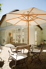 Chairs and table under umbrella in backyard