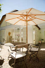 Chairs and table under umbrella in backyard