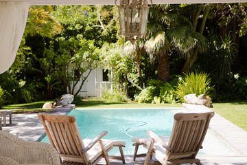 Lawn chairs and swimming pool in backyard