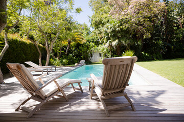 Lawn chairs and swimming pool in backyard